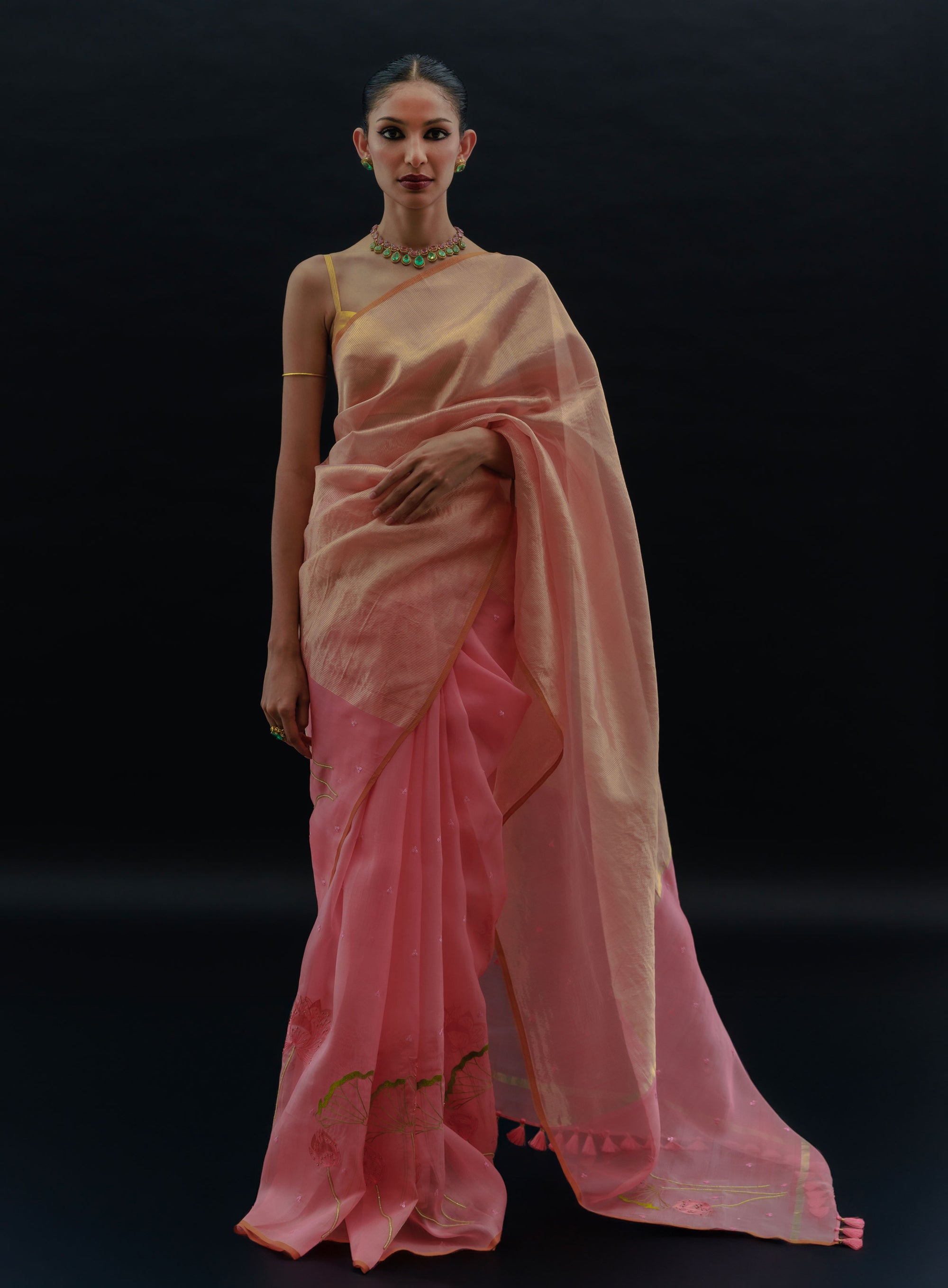 Woman wearing a pink saree with a black background